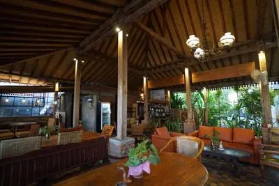 a restaurant with a table and chairs and a dining room at Oma Joglo Jimbaran in Jimbaran