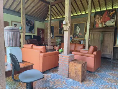 a living room with orange furniture and a fireplace at Oma Joglo Jimbaran in Jimbaran