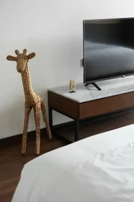 a toy giraffe standing next to a tv in a bedroom at Villa Talisman - Luxury Rooftop Canggu Villa Only 5 mins to Beach in Canggu