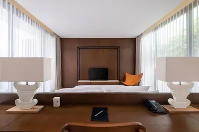 a bedroom with a bed with two lamps and a television at Villa Talisman - Luxury Rooftop Canggu Villa Only 5 mins to Beach in Canggu