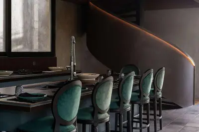 a dining room with green chairs and a table at Casa Madi Canggu in Canggu