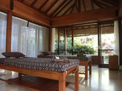 a bedroom with a bed in a room with windows at Dea Villas in Canggu