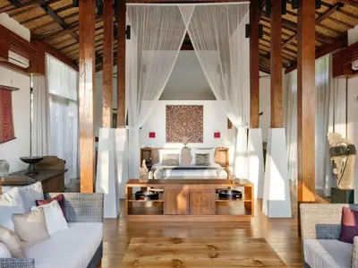 a bedroom with a bed and a couch in a room at Dea Villas in Canggu