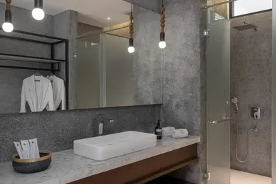 a bathroom with a sink and a shower and a mirror at Villa Talisman - Stylish Canggu with Rooftop Villa 5 mins to Beach in Canggu