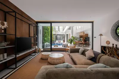 a living room with a couch and a tv at Villa Talisman - Stylish Canggu with Rooftop Villa 5 mins to Beach in Canggu