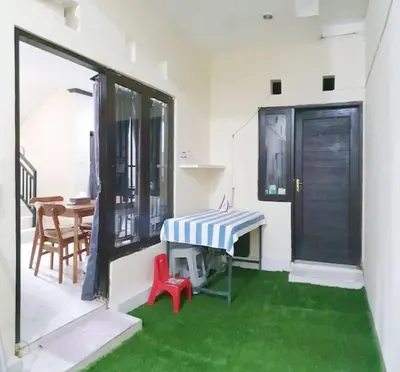 a living room with a table and a red chair at Laura Dewi House in Jimbaran