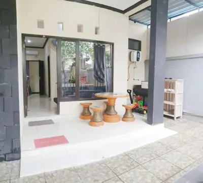 a room with a table and stools in it at Laura Dewi House in Jimbaran