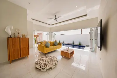 a living room with a yellow couch and a table at The Eclipse Villas - The Luxurious 2BR Private Pool Canggu Getaway in Canggu