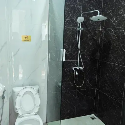 a bathroom with a shower with a toilet and a shower head at SONGOKU HOUSE APARTMEN in Pesanggaran