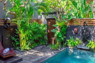a swimming pool in a garden with plants at Swaran 1 BR Private Pool Villa in Seminyak