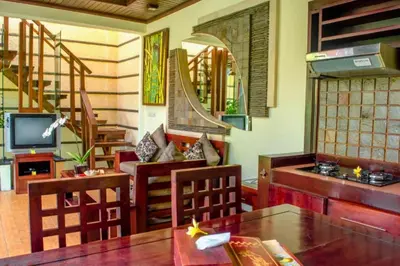 a living room with a table and chairs and a television at Bramanty 2 BR Private Pool Villa in Seminyak