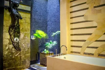 a bathroom with a tub and a shower with plants at Bramanty 2 BR Private Pool Villa in Seminyak