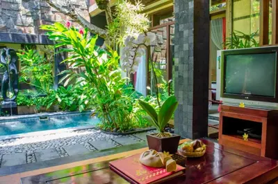 a living room with a tv and a swimming pool at Bramanty 2 BR Private Pool Villa in Seminyak