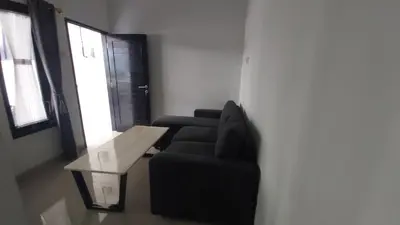 a living room with a black couch and a table at Chandra's house in Pesanggaran