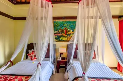 two beds in a bedroom with mosquito nets at Kastara 4 BR Private Pool Villa in Seminyak