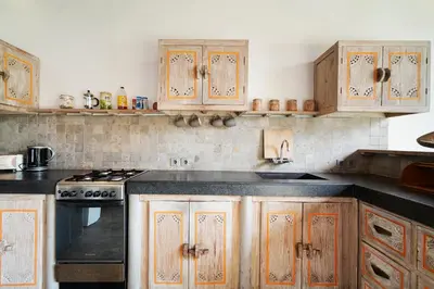 a kitchen with wooden cabinets and a stove top oven at Villa Anais Seminyak in Seminyak