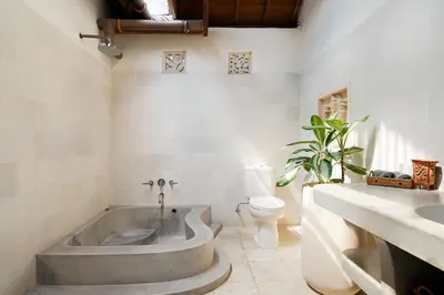 a bathroom with a large tub and a toilet at Villa Anais Seminyak in Seminyak