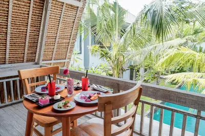 a table with food on top of a balcony at Sunrise Suite Seminyak by ARM Hospitality in Kerobokan