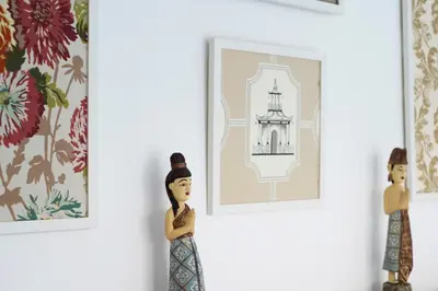 two wooden dolls looking at a picture of a lighthouse at Villa Angela in Seminyak