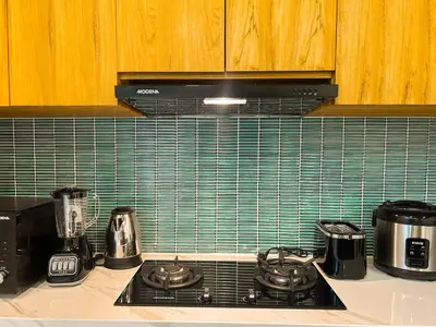 a kitchen counter with a stove top with green tiles at Villa Prada II 3BR Villa Near to Beach in Seminyak in Seminyak