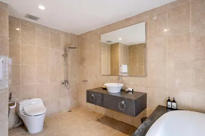 a bathroom with a tub and a toilet and a sink at Kings Villas Sanur by Moria in Denpasar