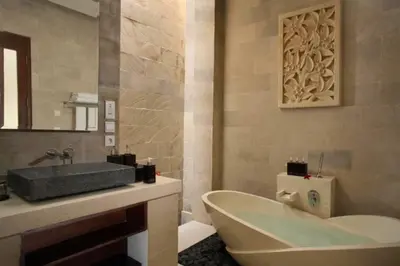 a bathroom with a tub and a sink and a mirror at Vadjar 1 BR Private Pool Villa in Seminyak