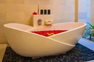 a bath tub filled with red flowers in a bathroom at Vadjar 1 BR Private Pool Villa in Seminyak