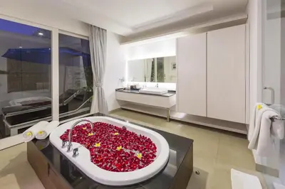 a bathroom with a large tub filled with red flowers at Bajra Bali Villa Seminyak in Seminyak