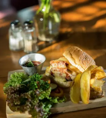 a plate of food with a sandwich and vegetables on a table at Liberta Seminyak Hotel in Seminyak