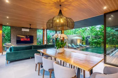 a dining room with a large wooden table and chairs at The Continental Modern Luxury 4 BR Villa in Seminyak Central in Seminyak