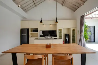 a kitchen with a wooden table and chairs at Anakula 1 - Modern 2 BR Villa, Seminyak in Seminyak