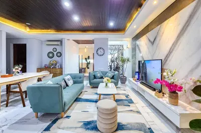 a living room with a blue couch and a tv at Villa Rumpi Seminyak by Nagisa Bali in Legian