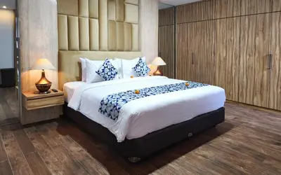 a bedroom with a large bed with blue and white pillows at Villa Rumpi Seminyak by Nagisa Bali in Legian