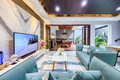 a living room with blue couches and a large tv at Villa Rumpi Seminyak by Nagisa Bali in Legian