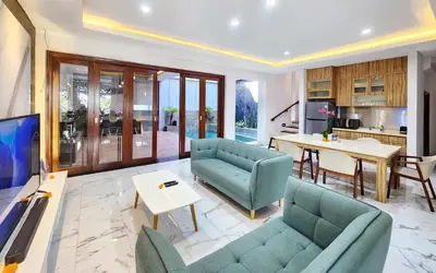 a living room with two blue couches and a table at Villa Rumpi Seminyak by Nagisa Bali in Legian