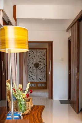 a living room with a table with a lamp and flowers at Stylish Tropical Villa 2 Br , Canggu , 400m To Finn Beach in Canggu