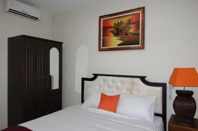 a bedroom with a bed and a picture on the wall at Tuban Torres Accommodation in Kuta
