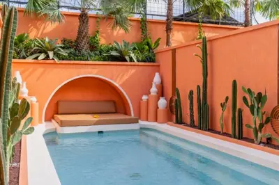 a swimming pool with a bed next to a house at Modern 1BR Private Pool Villa With Bathtub in Seminyak
