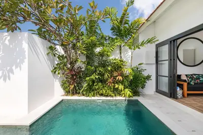 an indoor pool in the backyard of a house with plants at Villa Jabula in Seminyak