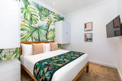 a bedroom with a bed with a tropical mural on the wall at Villa Jabula in Seminyak