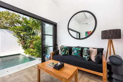 a living room with a couch and a mirror at Villa Jabula in Seminyak