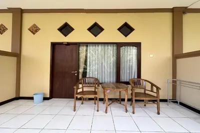 a dining room table and two chairs on a porch at Taxa Raya Guest House in Legian