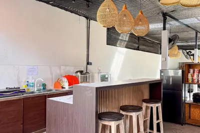 a kitchen with a counter with stools in it at Sekeca Coliving in Kuta