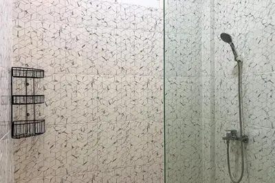 a shower stall with a glass door with a shower at Sekeca Coliving in Kuta