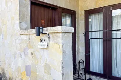a stone building with a door and a sign on it at Sekeca Coliving in Kuta