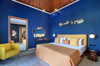 a blue bedroom with a bed and a yellow chair at ATLAS BEACH FEST CHILL 6bed VILLA LOVED by BiG GROUPS EASY Walk to Beach in Canggu