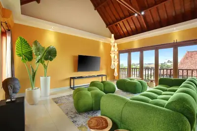a living room with a green couch and a flat screen tv at ATLAS BEACH FEST CHILL 6bed VILLA LOVED by BiG GROUPS EASY Walk to Beach in Canggu