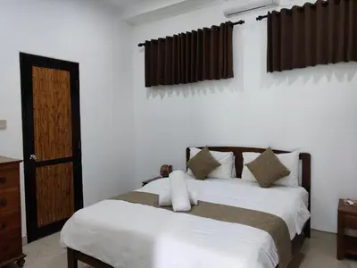 a bedroom with a bed with white sheets and brown curtains at Casa Yenny Balinese Style Villa by GLOBALSTAY - Seminyak x Kuta x Canggu in Seminyak