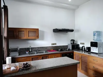 a kitchen with wooden cabinets and a counter top at Casa Yenny Balinese Style Villa by GLOBALSTAY - Seminyak x Kuta x Canggu in Seminyak