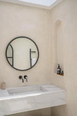 a bathroom with a sink and a round mirror at Villa Golden Canggu - Modern Chic 2BR Villa Near Finns Recreation Club in Canggu